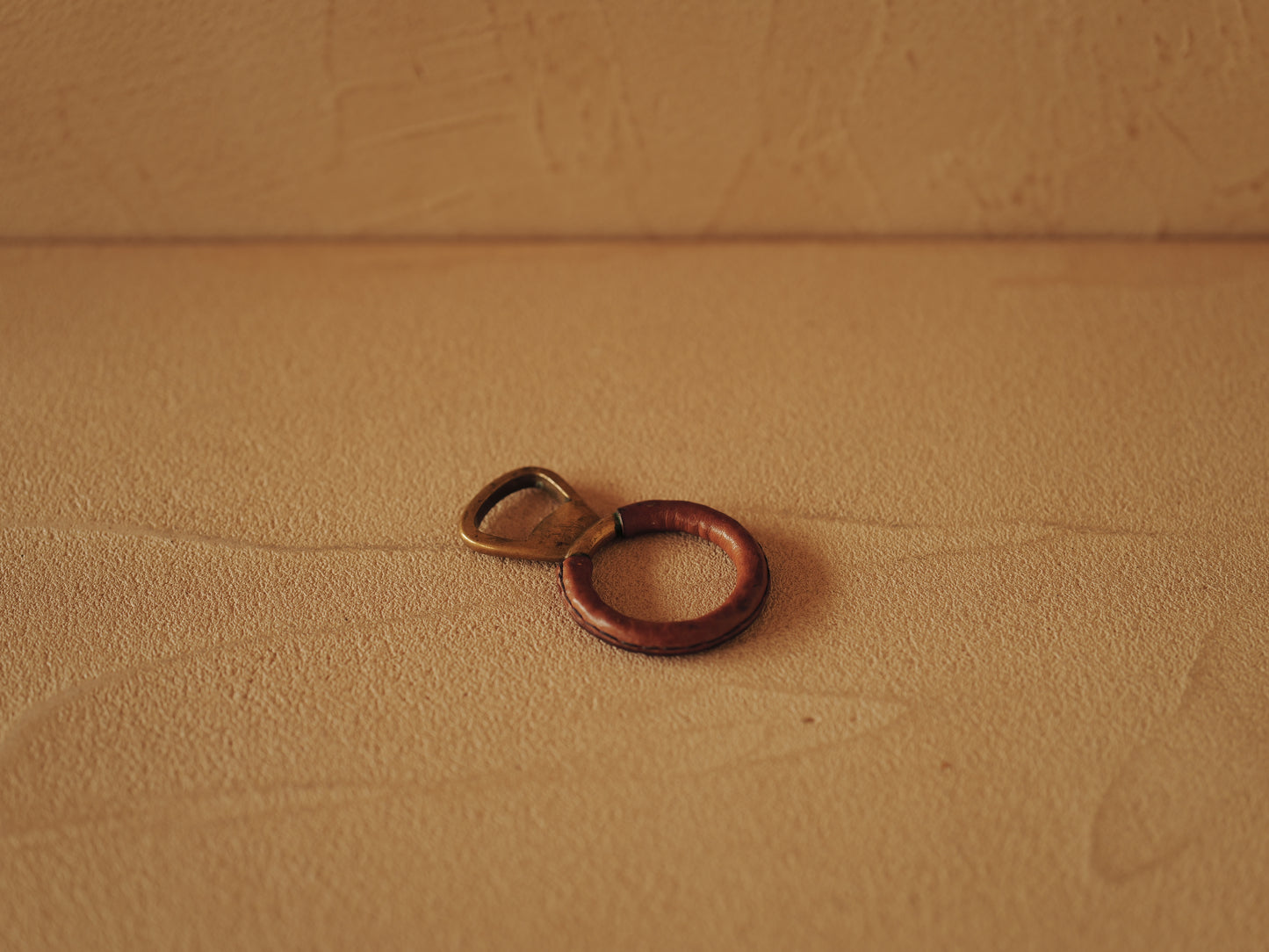 Carl Auböck One in brass with round handle covered with brown leather. Modell 4229.