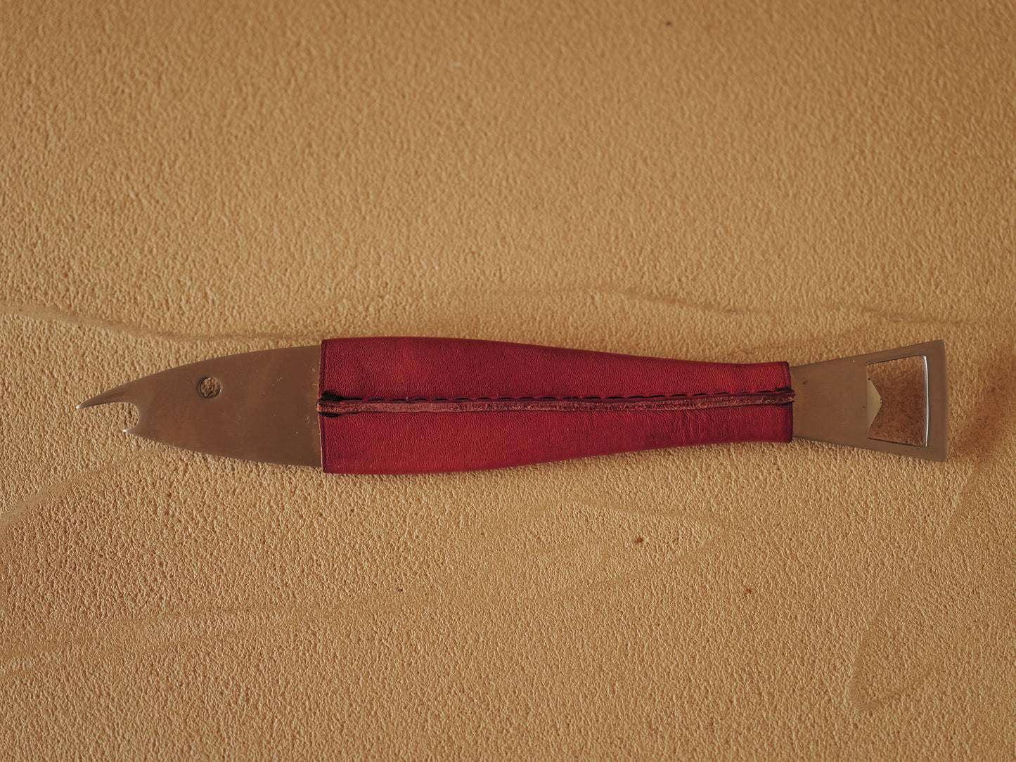 Carl Auböck One shaped like a fish in steel, covered in red leather. Model 4687
