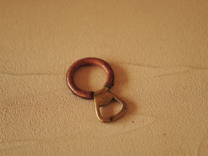 Carl Auböck One in brass with round handle covered with brown leather. Modell 4229.