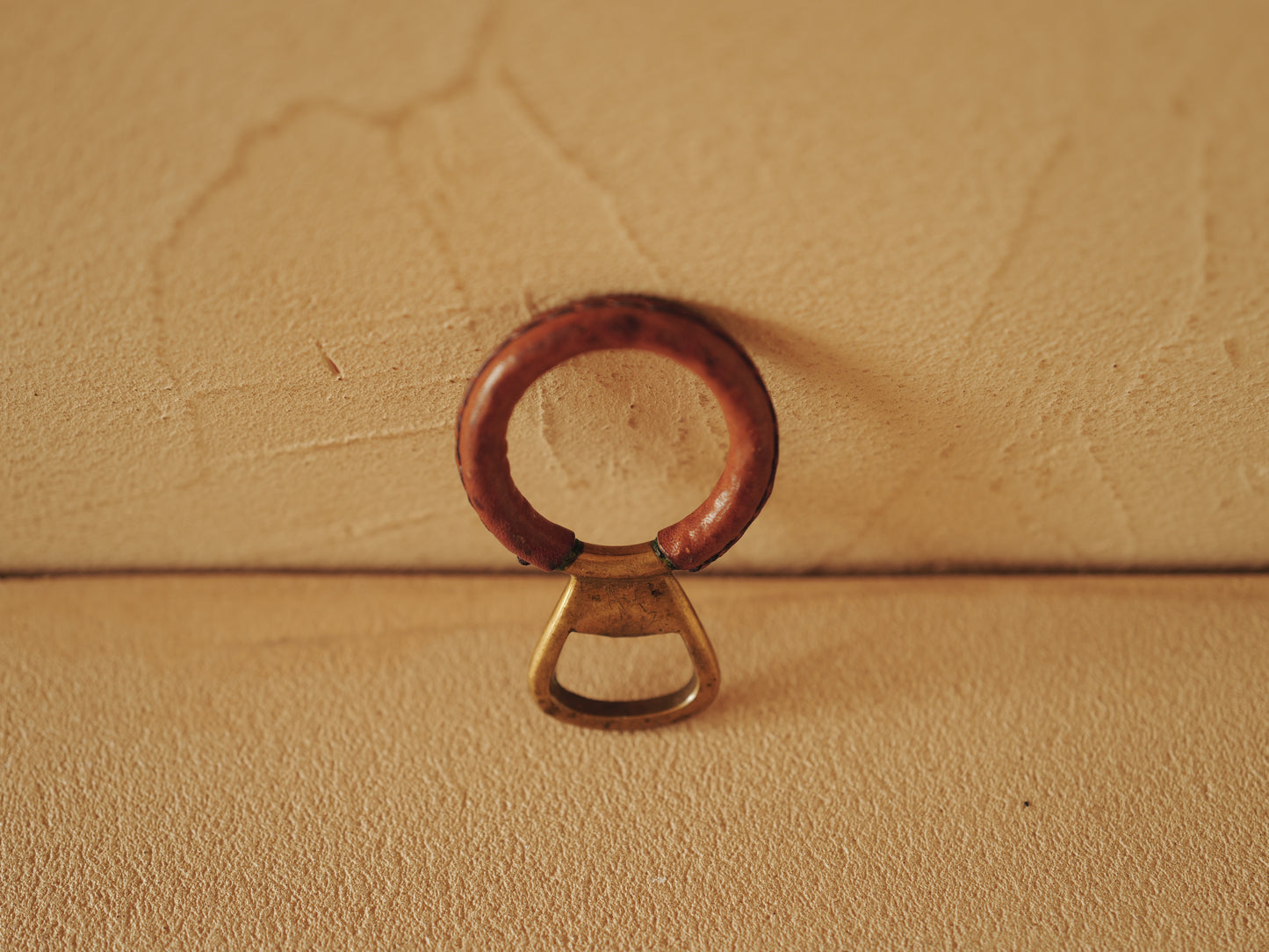 Carl Auböck One in brass with round handle covered with brown leather. Modell 4229.