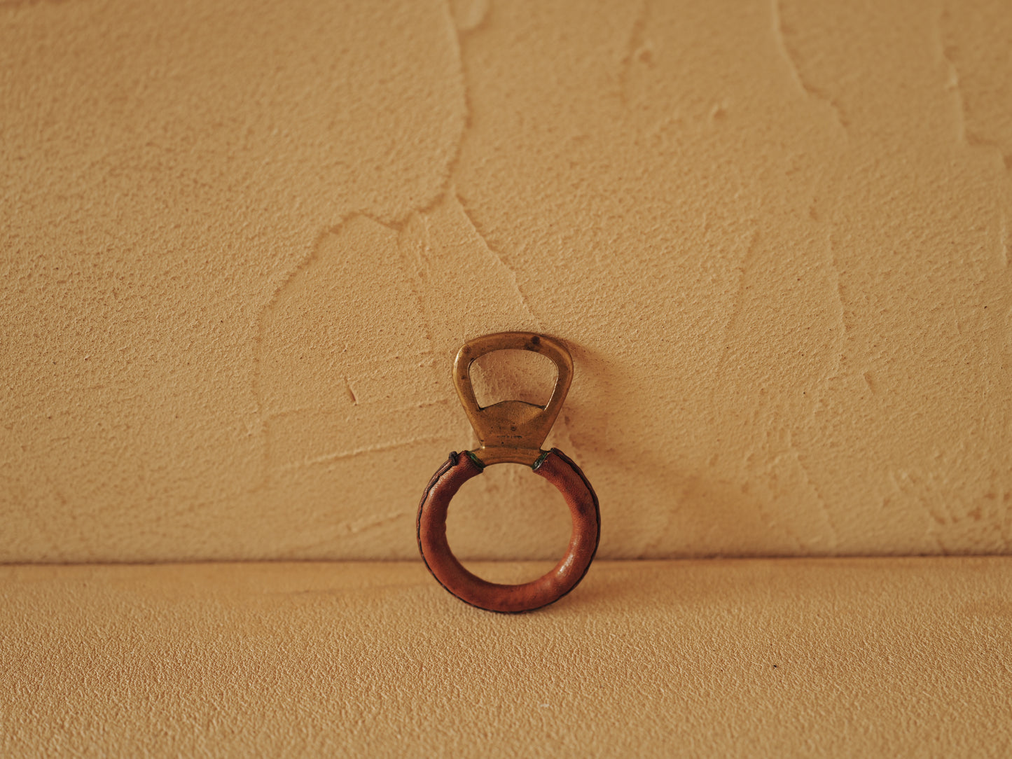 Carl Auböck One in brass with round handle covered with brown leather. Modell 4229.