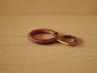 Carl Auböck One in brass with round handle covered with brown leather. Modell 4229.