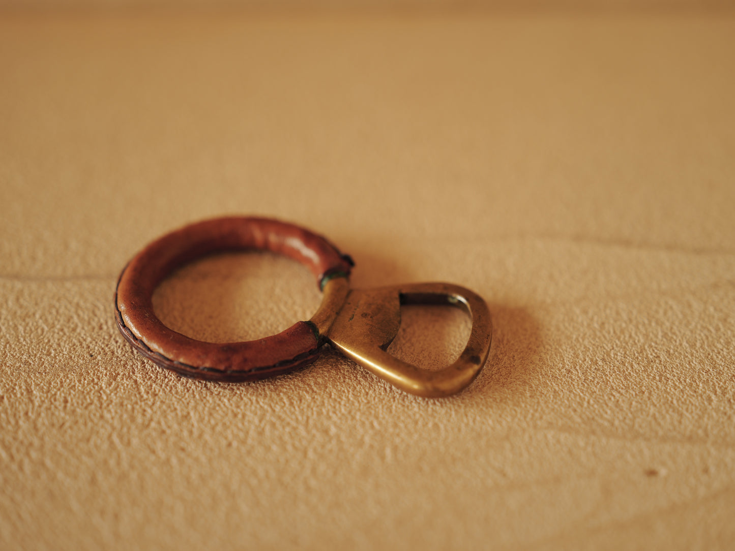 Carl Auböck One in brass with round handle covered with brown leather. Modell 4229.