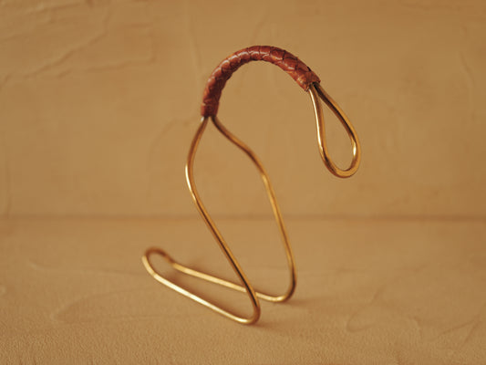 Carl Auböck model 3601 bottle holders of brass, braided leather, Illums Bolighus, Denmark 1957