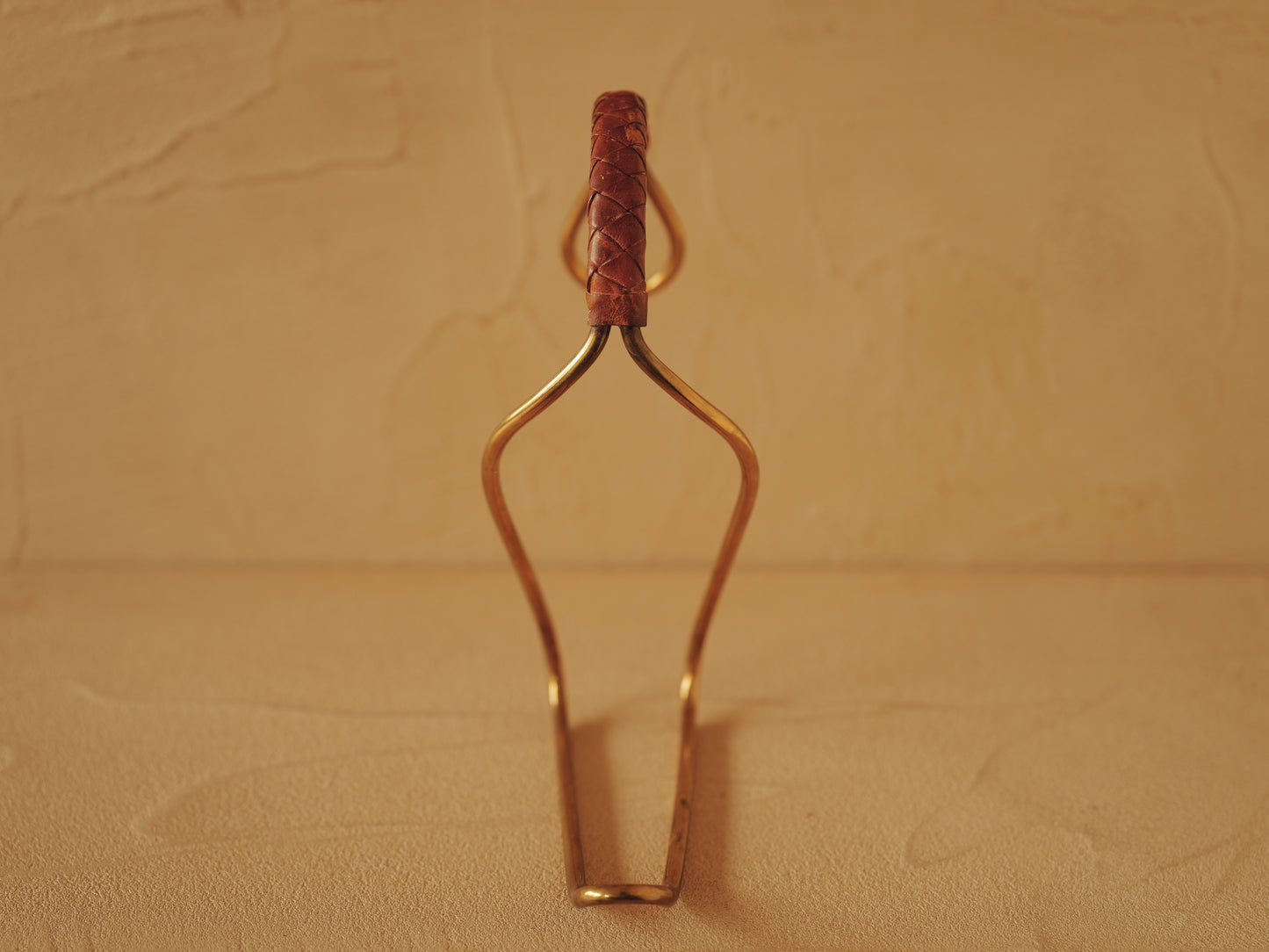 Carl Auböck model 3601 bottle holders of brass, braided leather, Illums Bolighus, Denmark 1957