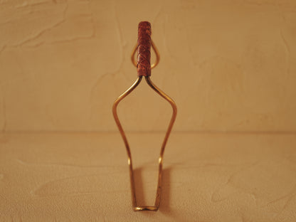 Carl Auböck model 3601 bottle holders of brass, braided leather, Illums Bolighus, Denmark 1957